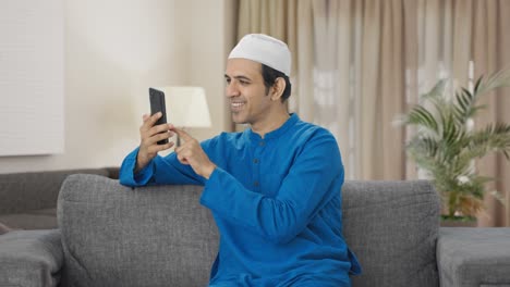 Hombre-Musulmán-Feliz-Desplazándose-Por-El-Teléfono