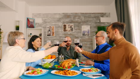 Young-man-clinking-a-glass-of-wine-with-his-family