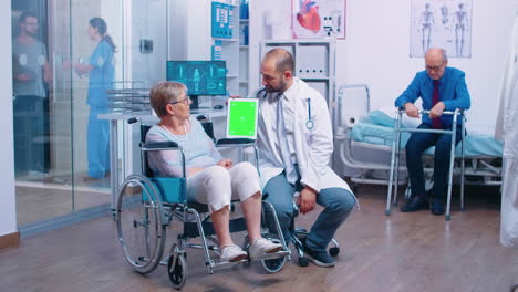 Doctor-with-green-screen-tablet-in-rehabilitation-center