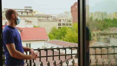 Man-trying-to-relax-on-the-balcony-of-his-apartment