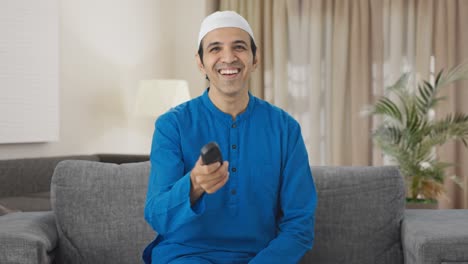 Glücklicher-Muslimischer-Mann,-Der-Beim-Fernsehen-Lacht