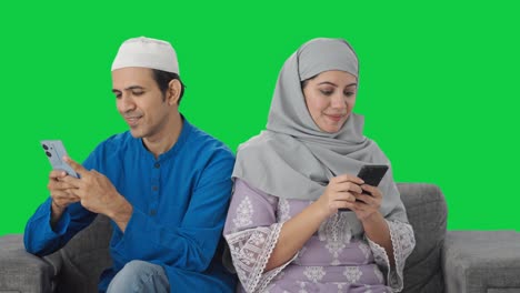 Glückliches-Muslimisches-Paar,-Das-Auf-Dem-Grünen-Bildschirm-Seines-Telefons-Beschäftigt-Ist