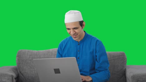Glücklicher-Muslimischer-Mann,-Der-Bei-Einem-Videoanruf-Auf-Dem-Grünen-Bildschirm-Des-Laptops-Spricht