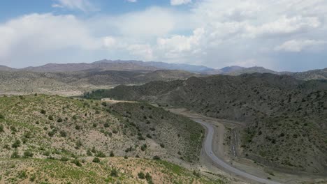 Paktia's-Afghan-mountains,-viewed-from-a-drone,-split-by-a-road