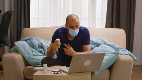 Man-wearing-mask-on-a-video-call-with-his-doctor