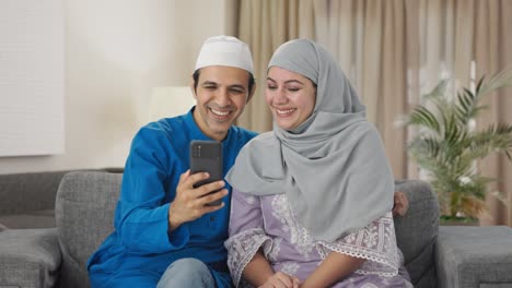 Happy-Muslim-couple-talking-their-child-on-video-call