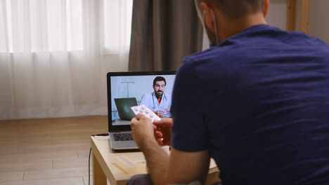 Man-listening-his-doctor-on-video-call