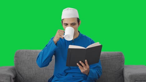 Glücklicher-Muslimischer-Mann,-Der-Ein-Buch-Liest-Und-Tee-Auf-Grünem-Bildschirm-Trinkt