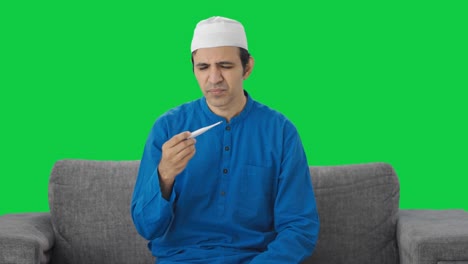Kranker-Muslimischer-Mann-überprüft-Fieber-Mit-Grünem-Thermometer-Bildschirm