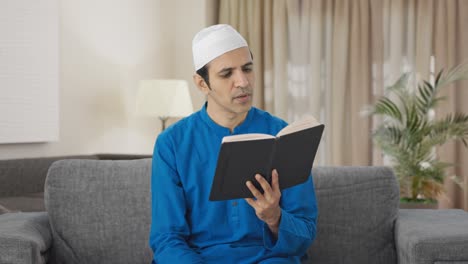 Hombre-Musulmán-Serio-Leyendo-Un-Libro-Y-Bebiendo-Té