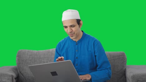 Glücklicher-Muslimischer-Manager,-Der-Bei-Einem-Videoanruf-Auf-Dem-Grünen-Bildschirm-Des-Laptops-Spricht