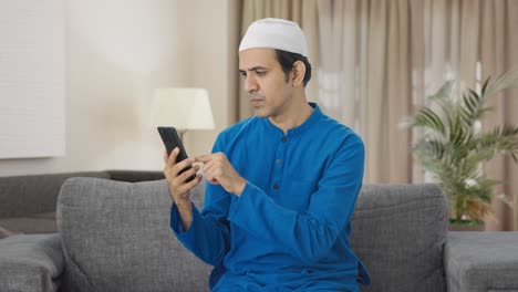 Hombre-Musulmán-Desplazándose-Por-El-Teléfono