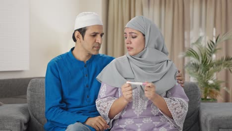 Sad-Muslim-couple-checking-pregnancy-test