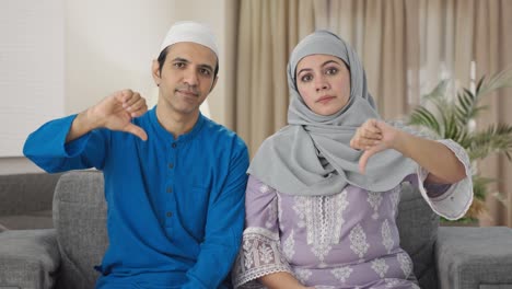 Disappointed-Muslim-couple-showing-thumbs-down