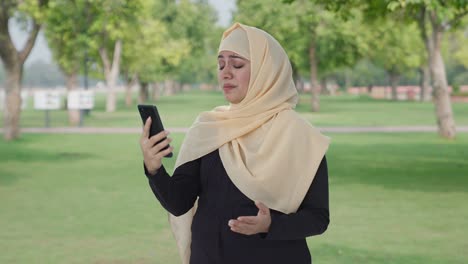 Angry-Muslim-woman-talking-on-video-call-in-park
