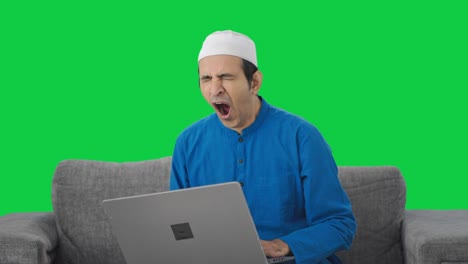 Tired-Muslim-man-using-laptop-Green-screen