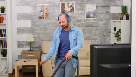 Bold-man-with-blue-headphone-vacuuming