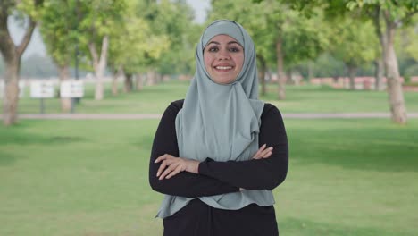 Mujer-Musulmana-Feliz-De-Pie-Con-Las-Manos-Cruzadas-En-El-Parque