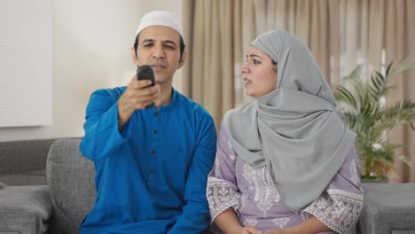 Wütendes-Muslimisches-Paar,-Das-Um-Die-Fernbedienung-Des-Fernsehers-Kämpft