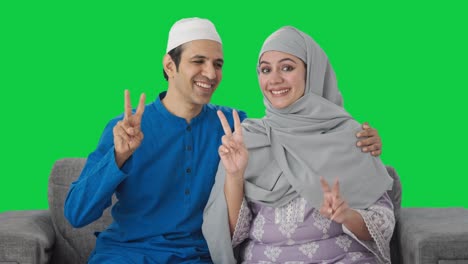 Feliz-Pareja-Musulmana-Mostrando-El-Signo-De-La-Victoria-En-La-Pantalla-Verde