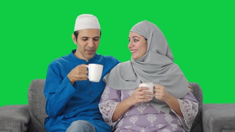 Glückliches-Muslimisches-Paar,-Das-Tee-Trinkt-Und-Den-Grünen-Bildschirm-Genießt