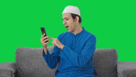 Fauler-Muslimischer-Mann-Scrollt-Durch-Den-Grünen-Bildschirm-Des-Telefons