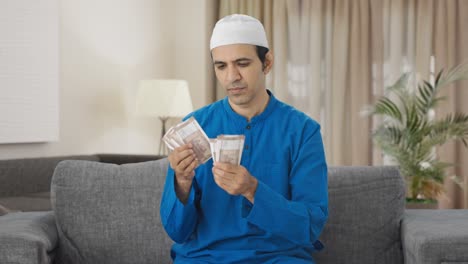 Sad-Muslim-man-counting-money