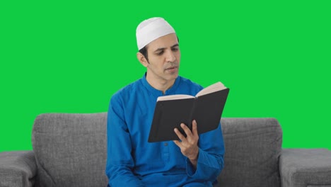 Serious-Muslim-man-reading-book-and-drinking-tea-Green-screen