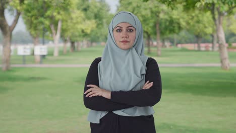 Confident-Muslim-woman-standing-crossed-hands-in-park