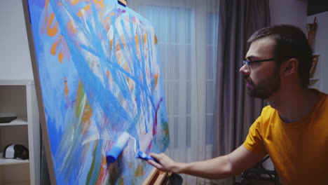 Man-with-glasses-painting-on-canvas