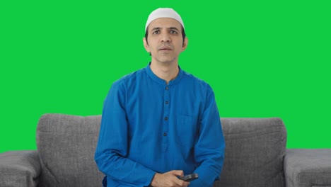 Muslimischer-Mann,-Der-Zu-Hause-Fernsieht,-Grüner-Bildschirm