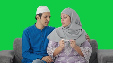 Trauriges-Muslimisches-Paar-überprüft-Schwangerschaftstest-Auf-Grünem-Bildschirm