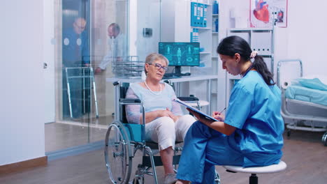 Nurse-talking-with-senior-woman-in-wheelchair