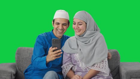 Glückliches-Muslimisches-Paar,-Das-Mit-Seinem-Kind-über-Einen-Videoanruf-Auf-Grünem-Bildschirm-Spricht