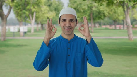 Un-Hombre-Musulmán-Feliz-Mostrando-Un-Cartel-Bien-En-El-Parque