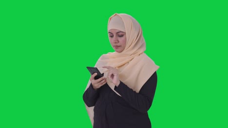 Muslimische-Frau,-Die-Einen-Grünen-Bildschirm-Am-Telefon-Benutzt