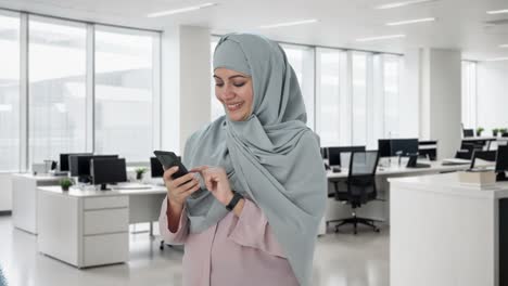 Happy-Muslim-businesswoman-using-phone