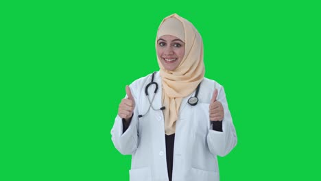 Feliz-Médico-Musulmán-Mostrando-Los-Pulgares-Hacia-Arriba-En-La-Pantalla-Verde