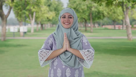Happy-Muslim-woman-doing-Namaste-in-park