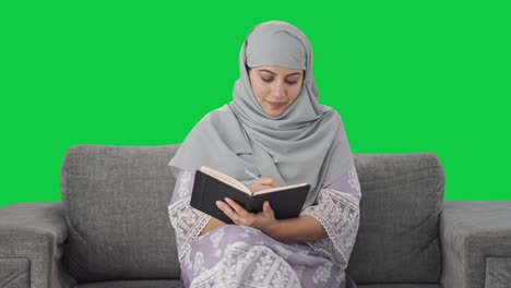 Glückliche-Muslimische-Frau,-Die-Tagebuch-Auf-Grünem-Bildschirm-Schreibt