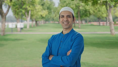 Porträt-Eines-Glücklichen-Muslimischen-Mannes,-Der-Mit-Gekreuzten-Händen-Im-Park-Steht