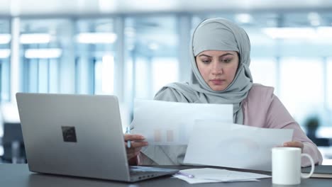 Muslimische-Geschäftsfrau-Liest-Und-Unterschreibt-Dokumente