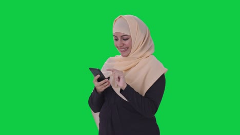 Mujer-Musulmana-Feliz-Usando-La-Pantalla-Verde-Del-Teléfono
