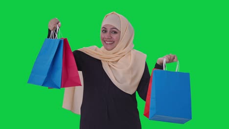 Mujer-Musulmana-Feliz-Posando-Con-Bolsas-De-Compras-Pantalla-Verde