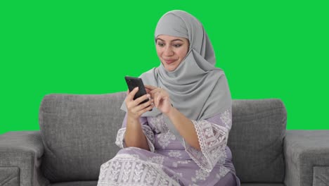 Mujer-Musulmana-Feliz-Usando-La-Pantalla-Verde-Del-Teléfono-Móvil