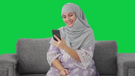 Glückliche-Muslimische-Frau,-Die-über-Einen-Videoanruf-Auf-Grünem-Bildschirm-Spricht