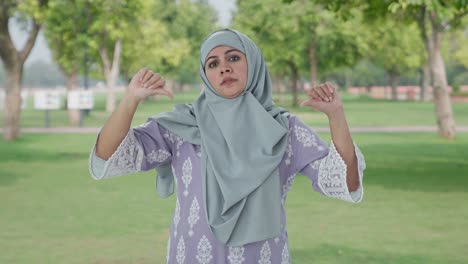 Disappointed-Muslim-woman-showing-thumbs-down-in-park