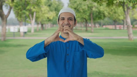 Hombre-Musulmán-Feliz-Mostrando-El-Signo-Del-Corazón-En-El-Parque