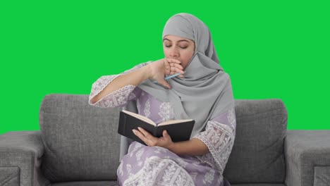 Mujer-Musulmana-Soñolienta-Escribiendo-Un-Diario-Con-Pantalla-Verde
