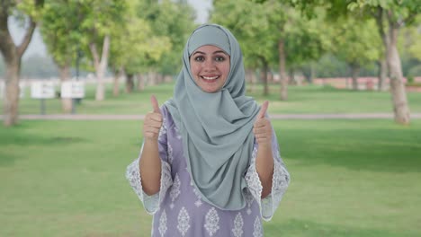Glückliche-Muslimische-Frau-Zeigt-Daumen-Nach-Oben-Im-Park